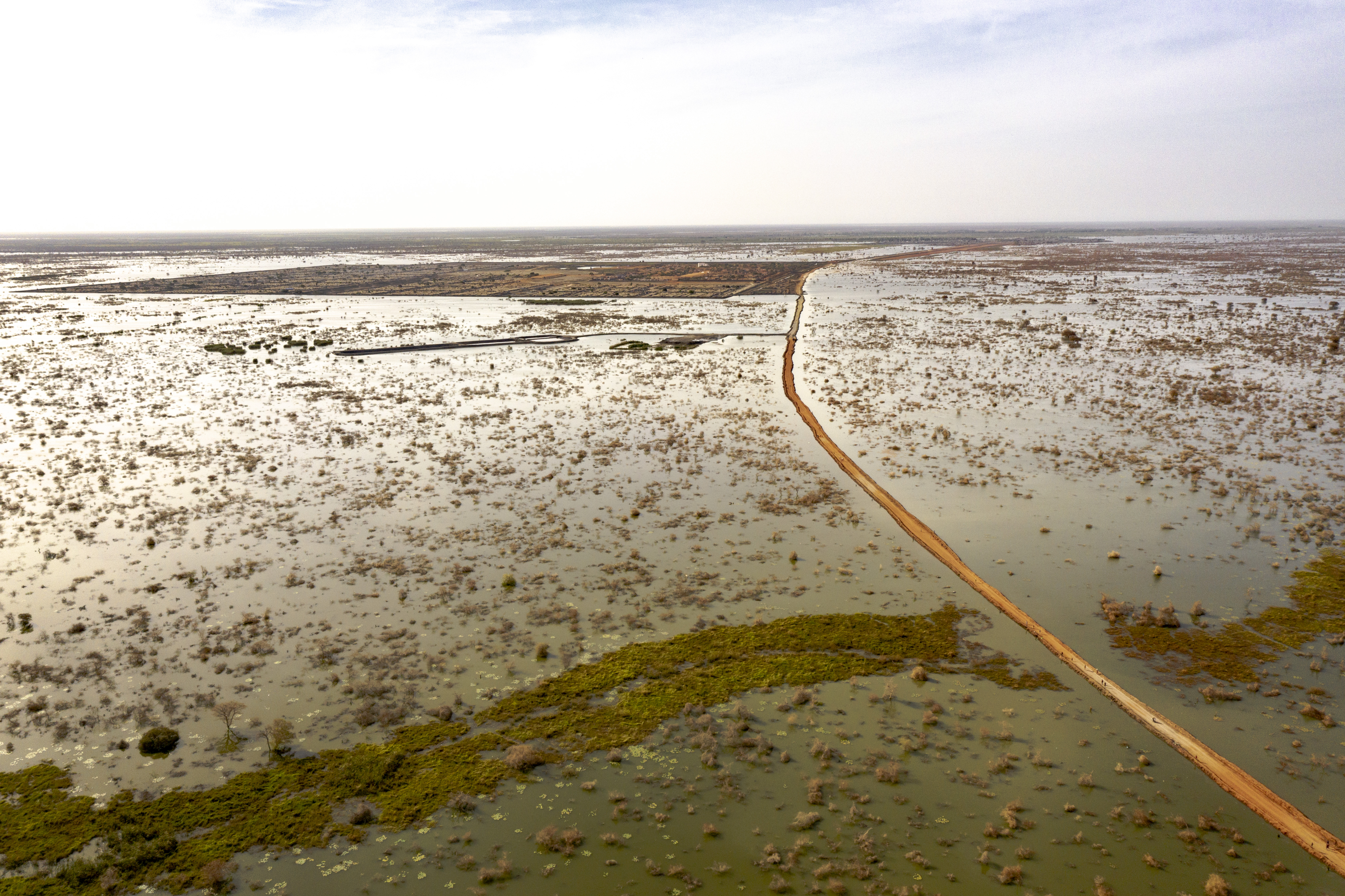 Uma estrada protegida por diques conduz ao campo de deslocados internos de Bentiu, visto à distância. 