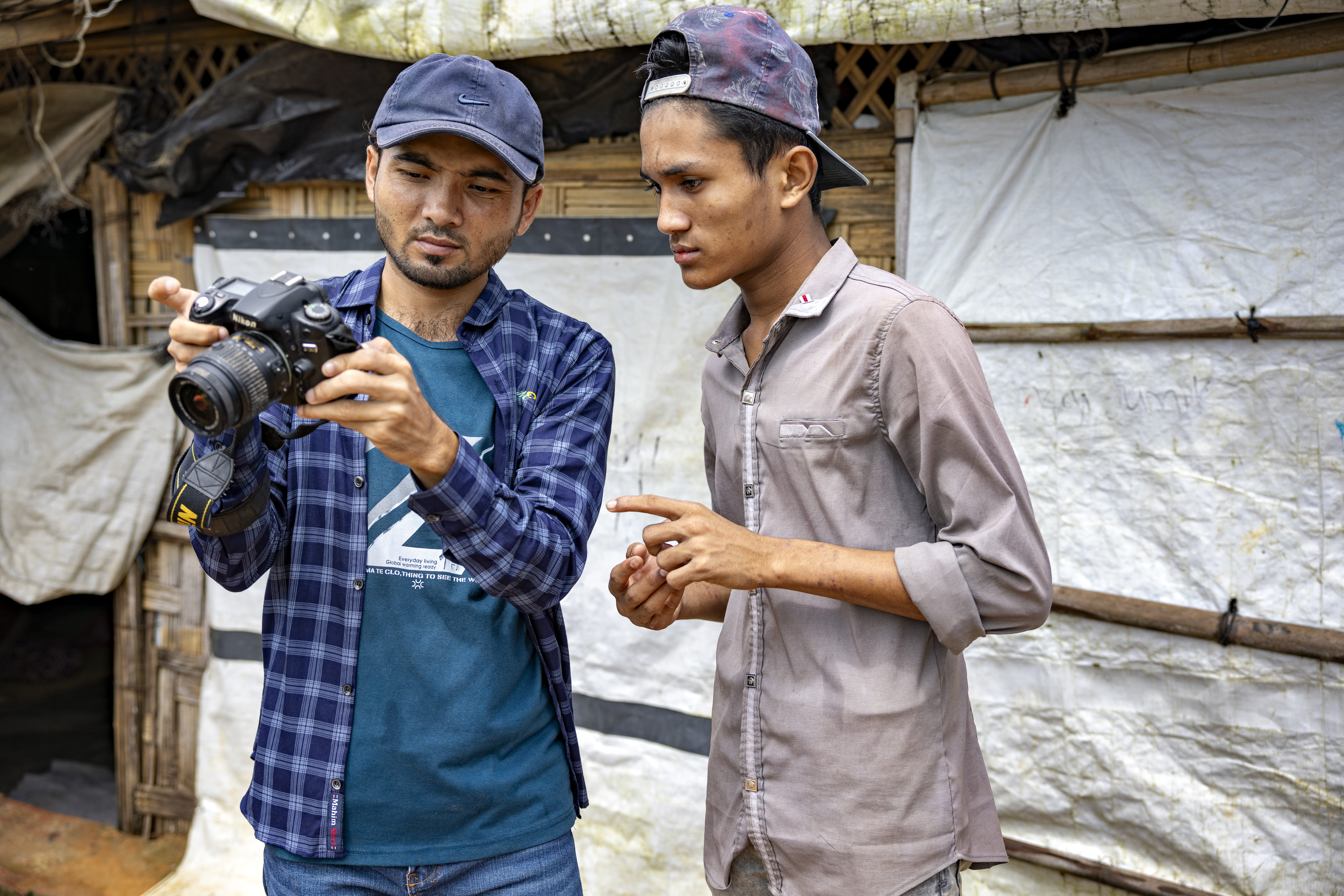 Sahat Zia Hero (à esquerda) orienta o jovem Rohingya, Mohammed Hassan. © UNHCR/Susan Hopper 