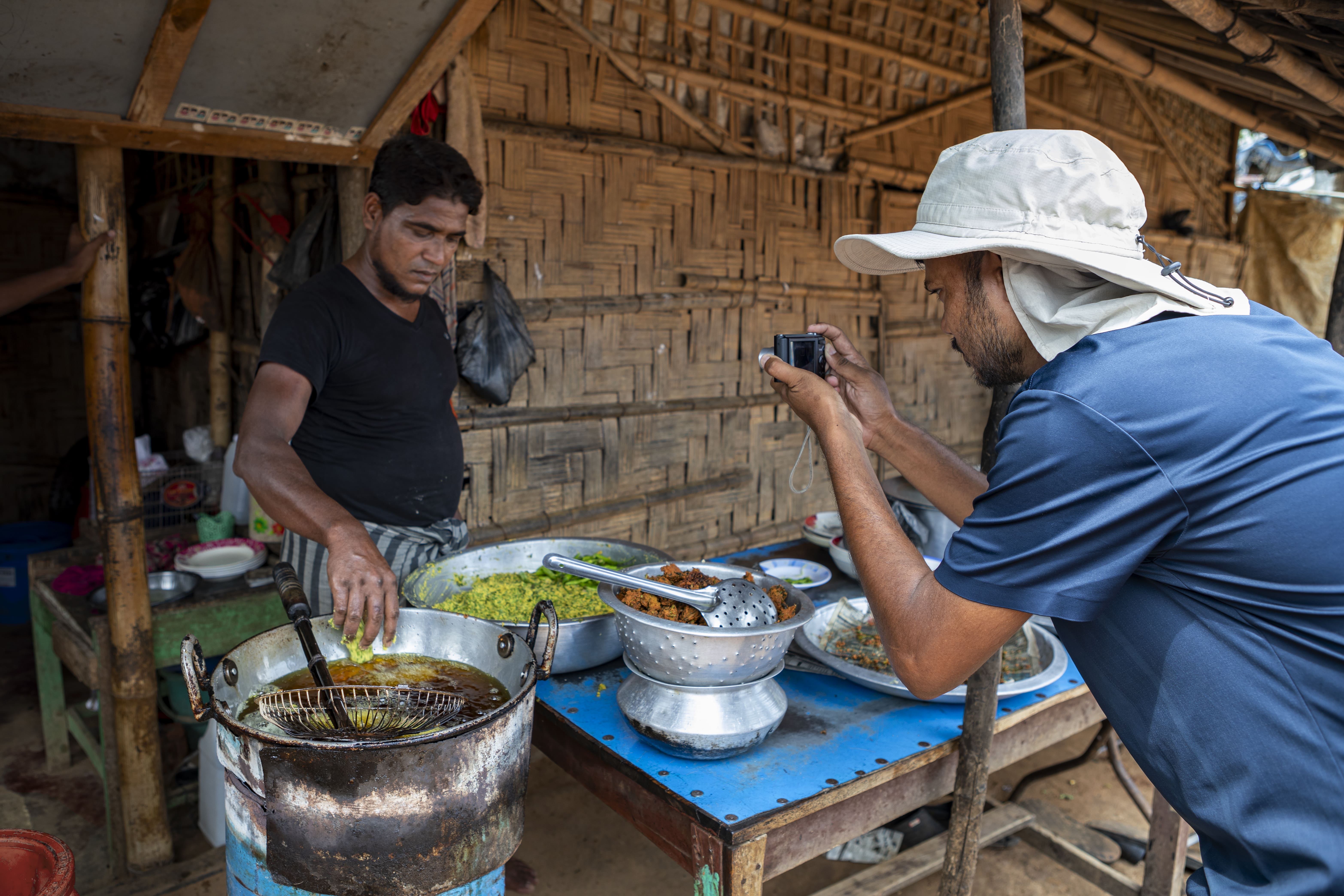 Salim Khan fotografa um homem Rohingya a preparar comida. © UNHCR/Susan Hopper 