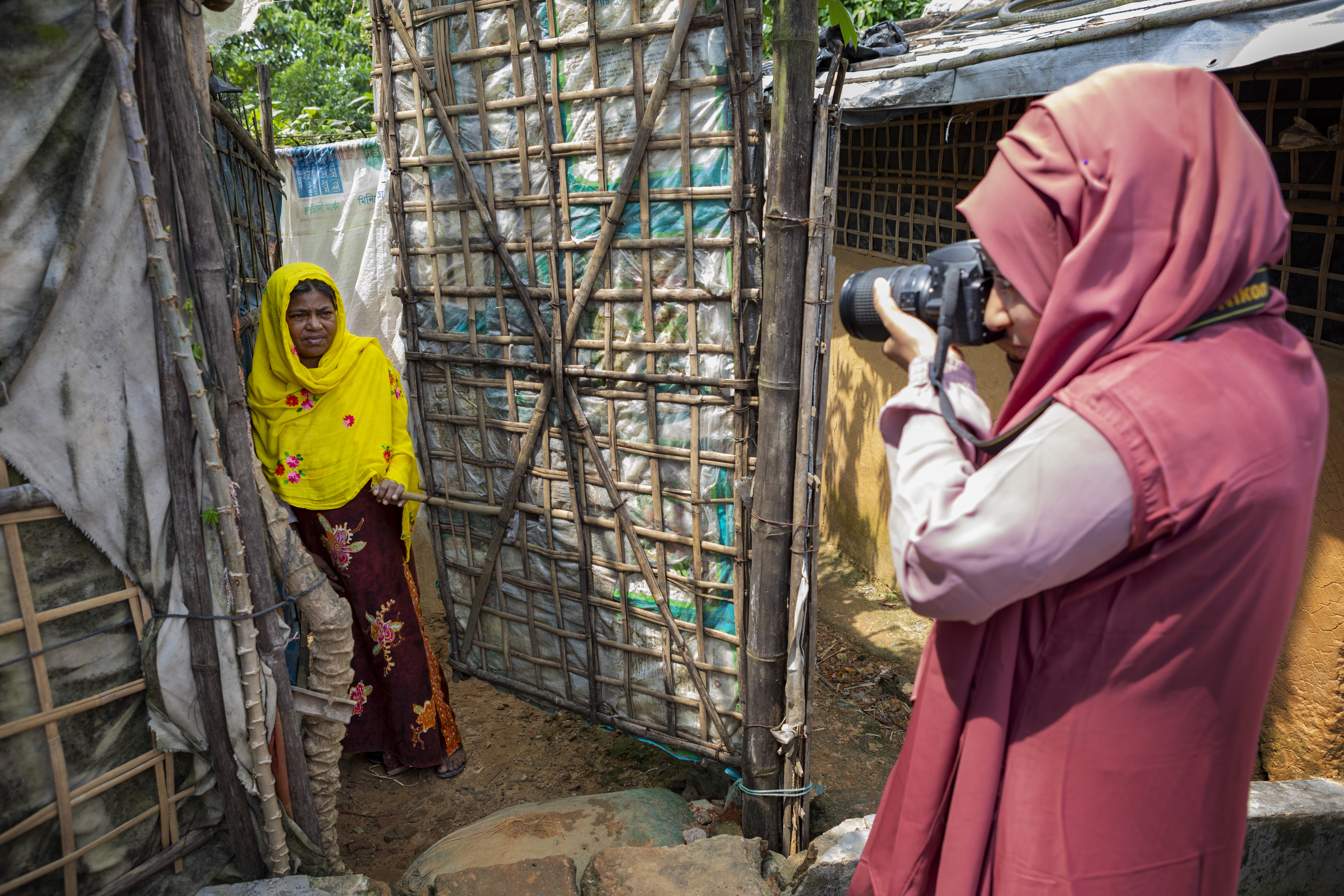 Shahida Win fotografa uma mulher Rohingya no campo de refugiados de Kutupalong.   © UNHCR/Susan Hopper 