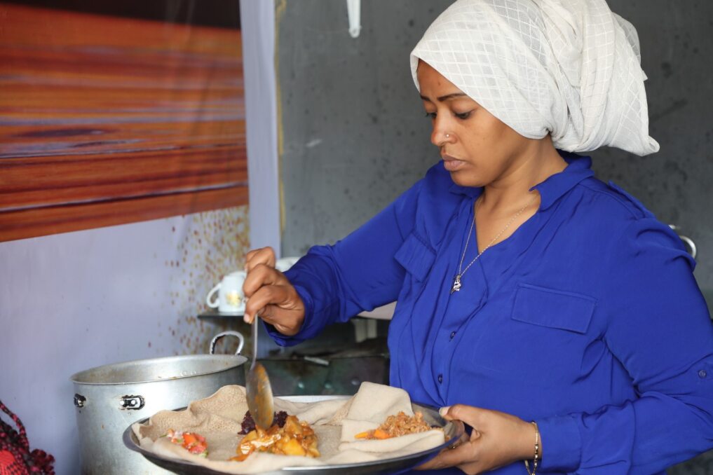 Ibtisam serve comida em Injera, um pão achatado tradicional etíope que faz no seu café. 